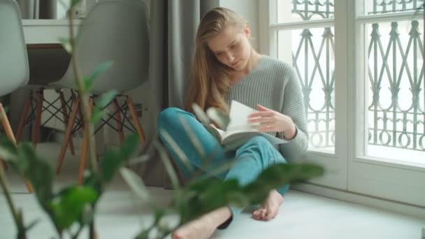 Junge Frau Hause Sitzt Fenster Und Liest Buch Und Entspannt — Stockvideo