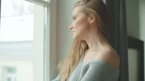 站在窗边的年轻沉思的女人 — 图库视频影像