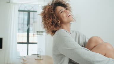 Mutlu genç afro Amerikan kadın evde mutfak masasında oturuyordu.