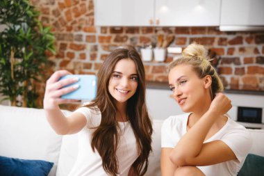 Evde selfie çeken iki genç kız..