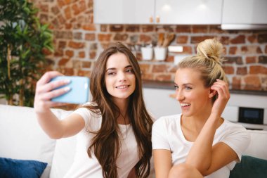 Evde selfie çeken iki genç kız..