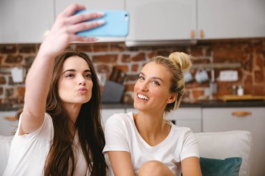 Evde selfie çeken iki genç kız..
