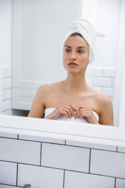 Aynanın önünde kendini inceleyen güzel bir genç kadının portresi..