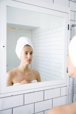 Aynanın önünde kendini inceleyen güzel bir genç kadının portresi..