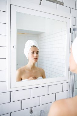 Aynanın önünde kendini inceleyen güzel bir genç kadının portresi..