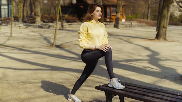 若いブルネットの女性が都市公園で演習をストレッチ — ストック写真