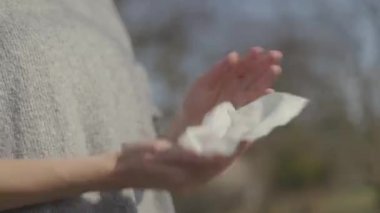 Kadın antiseptik ıslak mendille ellerini temizliyor.