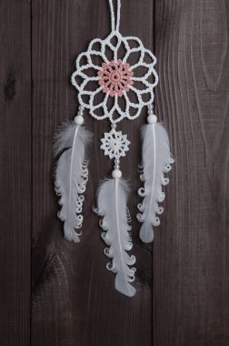 Kahverengi zemin üzerine beyaz rüya yakalayıcı