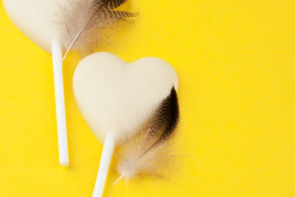 Два белых шоколадных сердечка на желтом — стоковое фото