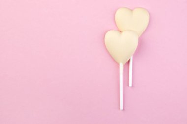 İki beyaz çikolata şeker kalp pembe üzerinde 