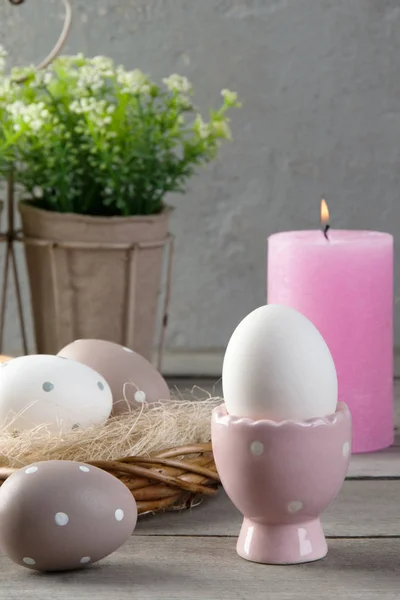 Eggs and rose aroma candle on old wooden background — Stock Photo, Image