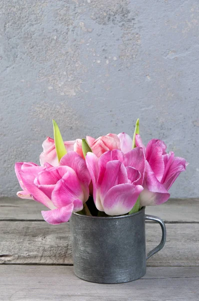 Рожеві тюльпани в старовинній металевій чашці — стокове фото