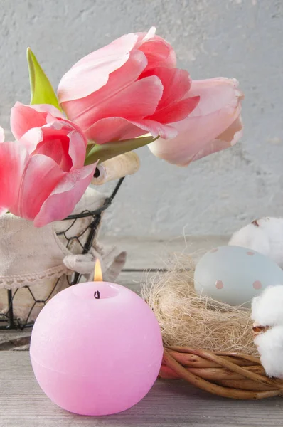 Vela de aroma rosa e tulipas de perto — Fotografia de Stock