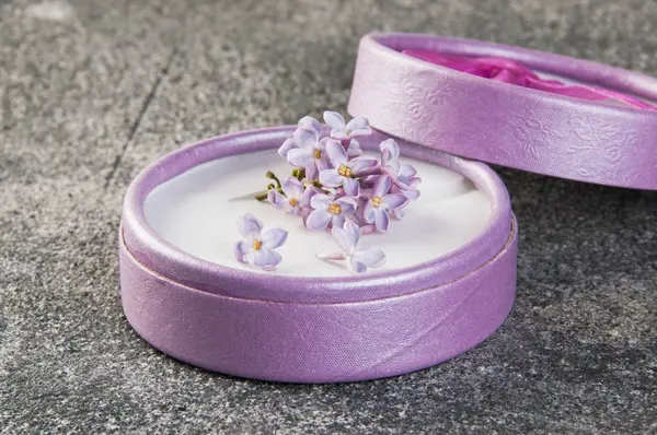 Caja de regalo y manojo de lila sobre fondo de hormigón gris —  Fotos de Stock