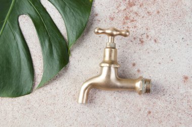 Beton zeminde antik bronz su musluğu.