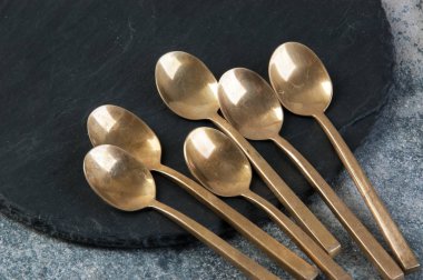 Old bronze coffee spoons on concrete 