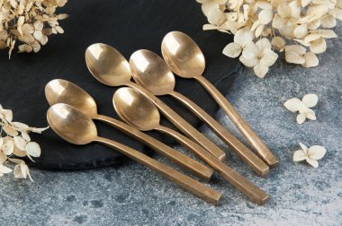 Old bronze coffee spoons on concrete 