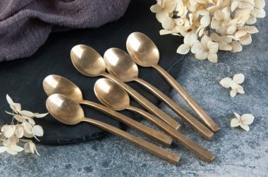 Old bronze coffee spoons on concrete 