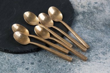 Old bronze coffee spoons on concrete 