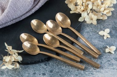 Old bronze coffee spoons on concrete 