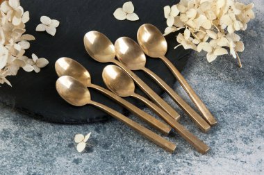 Old bronze coffee spoons on concrete 