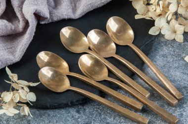 Old bronze coffee spoons on concrete 