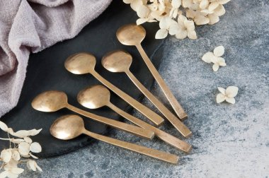 Old bronze coffee spoons on concrete 