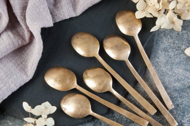 Old bronze coffee spoons on concrete 