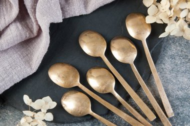 Old bronze coffee spoons on concrete 