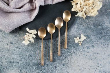 Old bronze coffee spoons on concrete 