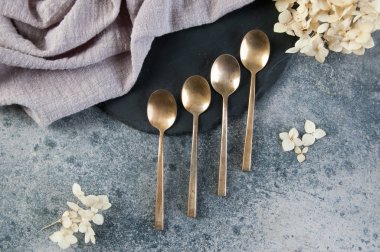 Old bronze coffee spoons on concrete 