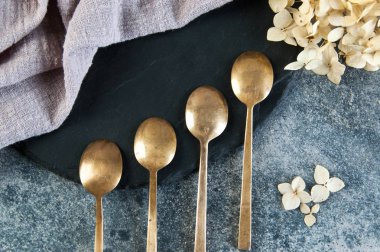 Old bronze coffee spoons on concrete 