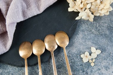 Old bronze coffee spoons on concrete 