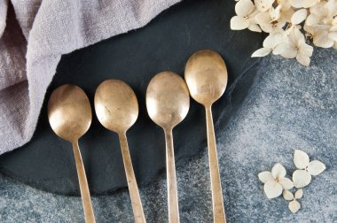 Old bronze coffee spoons on concrete 