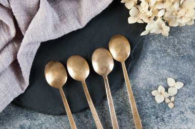 Old bronze coffee spoons on concrete 