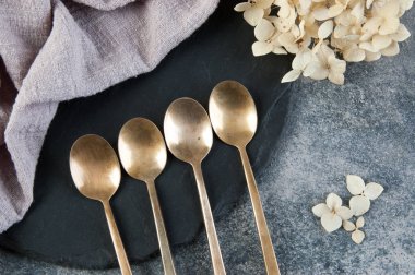 Old bronze coffee spoons on concrete 