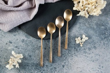 Old bronze coffee spoons on concrete 