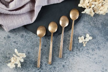 Old bronze coffee spoons on concrete 