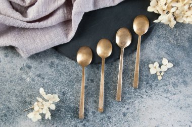 Old bronze coffee spoons on concrete 