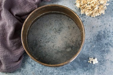 Beton zeminde antika pirinç elek.