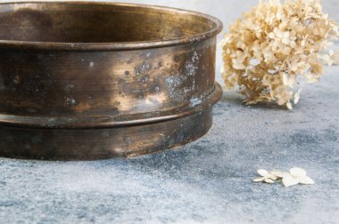 Beton zeminde antika pirinç elek.