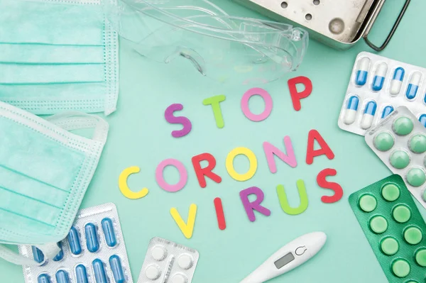 Words stop corona virus in colored letters, coronavirus protection on mint background. Copy space for text.