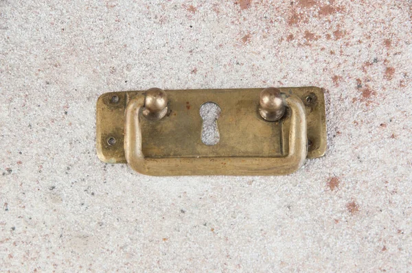 Antique brass drawer pull knob on concrete background. Copy space for text.