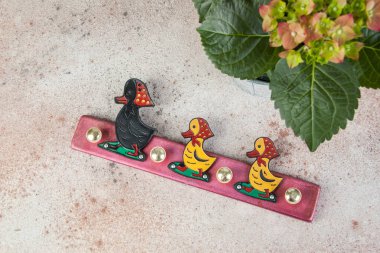 Klasik çocuk palto askısı ördek ve ortanca beton arka planda. Metin için alanı kopyala.