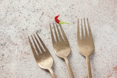 Üç eski bronz çatal ve arka planda küçük kırmızı biber. Metin ve yemek fotoğrafçılığı için boşluk kopyala.