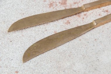 Beton zemine yakın iki bronz bıçak. Metin ve yemek fotoğrafçılığı için boşluk kopyala.