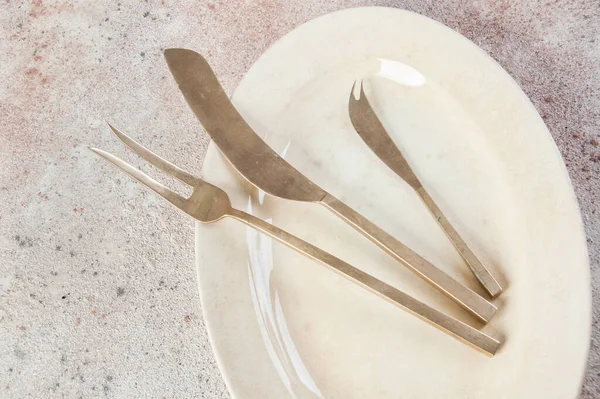具体的な背景にヴィンテージ楕円形のプレート上の肉やチーズのための3 大規模な古いフォークとナイフのブロンズセット テキストのためのコピースペース 食品写真小道具 ストック画像