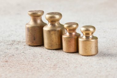 Beton arka planda pullar için dört antika bronz ağırlık. Metin ve yemek fotoğrafçılığı için alanı kopyala.