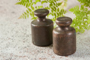 Beton arka planda pullar için iki antika bronz ağırlık. Metin ve yemek fotoğrafçılığı için alanı kopyala.