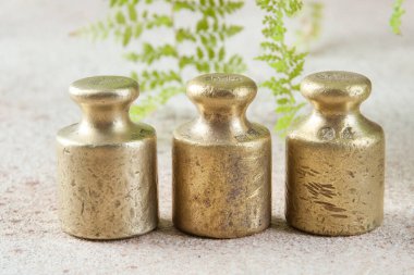 Beton arka planda pullar için üç antika bronz ağırlık. Metin ve yemek fotoğrafçılığı için alanı kopyala.
